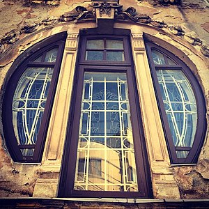 Mix of Art Nouveau and Egyptian Revival – Round corner window of the Romulus Porescu House (Strada Doctor Paleologu no. 12) in Bucharest, decorated with lotus flowers, a motif used frequently in Ancient Egyptian art, designed by Dimitrie Maimarolu (1905)[178]