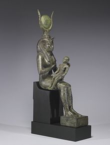 Small statue of a seated woman, with a headdress of horns and a disk, holding an infant across her lap