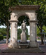 Statue of a bishop under a stone arch