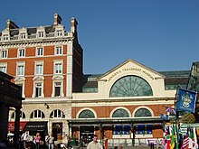 External view of the museum, a red brick building with a glass roof; the name of the museum curves around the top of a large semi-circular window