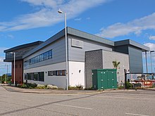 A grey-clad multi-storey college building with an industrial look.