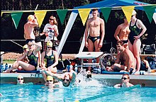 Swimmers posed in a group shot around the edge of a pool