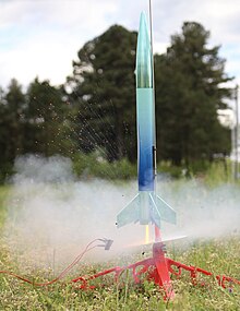 A photograph of a small model rocket being launched.