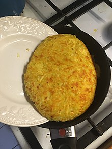 Rösti wird mithilfe eines Tellers gewendet.