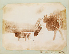 Salt print photograph of a man and woman building a snowman, circa 1853