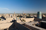 Look at a city from above, buildings in brick and a tower with ceramic tiles