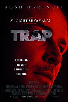 A man is bathed in red light, with the title TRAP superimposed on him in white lettering; one of his eyes is set in the center of the "A".