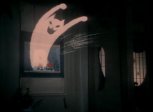 A cartoon-like image of a grinning cat leaps out of a picture of Blanche in the aunt's house