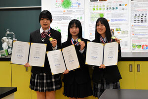 台湾で1月に開催された台湾国際科学フェアに日本代表として出場し、1位に輝いた（左から）飯山高2年の藤沢佳美さん、大塚結愛さん、高藤陽菜果さん=飯山市