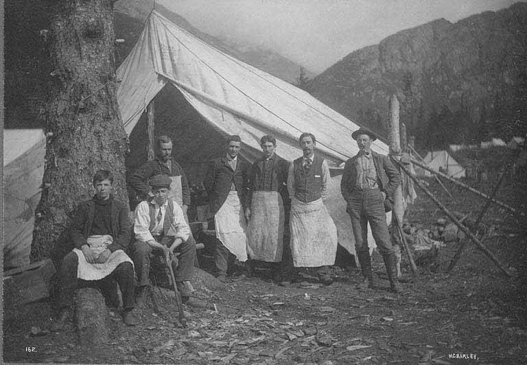 File:Cooks and mess help posing in front of tent at railroad construction camp, White Pass and Yukon Railroad route, between 1893 and (AL+CA 1365).jpg