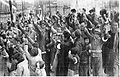 Chinese refugees cheering Japanese soldiers who are distributing candy and cigarettes to them on the day of the victory parade