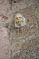 English: Sculpture of a human head at the southern wall Deutsch: Kopfskulptur aus Stein an der S-Wand