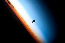 #11: The silhouette of space shuttle Endeavour seen against Earth's colorful horizon during shuttle mission STS-130