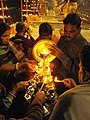 Multi-tiered aarti stand being lit, during Ganga Aarti, Varanasi.