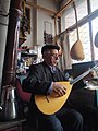 Alevi Baglama (Turkish folk instrument) repairman, who has been making baglama for years, plays the instrument he has repaired