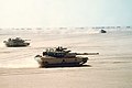 M1 Abrams tanks in formation across the desert.