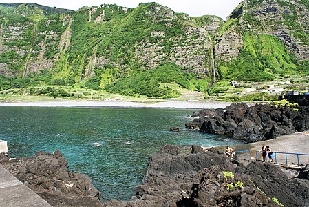 steep coast of Fajã Grande (zona balnear). Deutsch: Kleiner Hafen in Fajã Grande mit Blick auf die steilen Berge und Wasserfälle an der Küste.