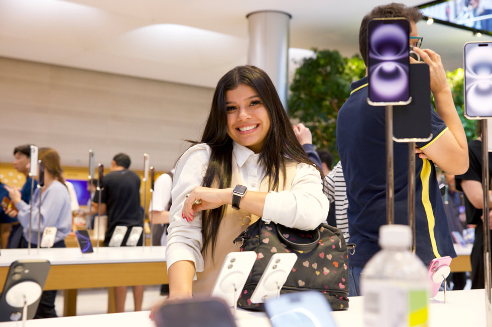 A smiling customer displays the new Apple Watch Series 10 at Apple Fifth Avenue in New York City.