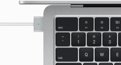 Vue de haut montrant un câble MagSafe relié à un MacBook Air en finition argent