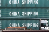 Một chiếc xe tải đi qua các container của China Shipping tại cảng Los Angeles, ở Long Beach, California, hôm 01/09/2019. (Ảnh: Mark Ralston/AFP qua Getty Images)