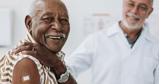 Senior man bandaging vaccine on arm