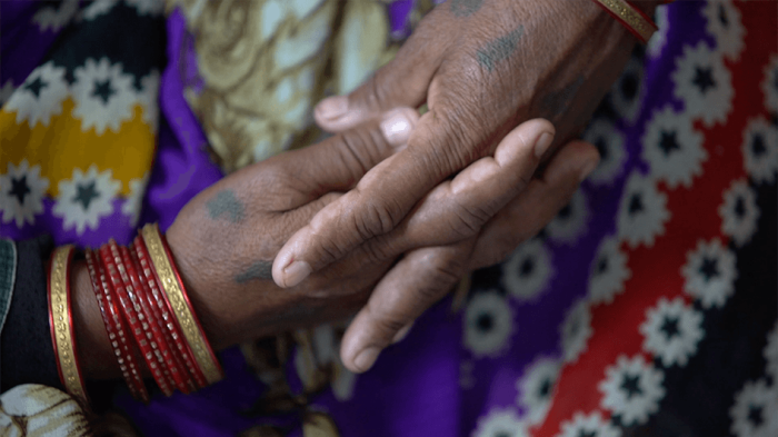 A close-up photo showing the hands of a sexual violence victim in India.