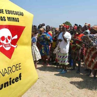 Villagers stand in front of a Unicef banner warning of landmines outside Caala, Angola