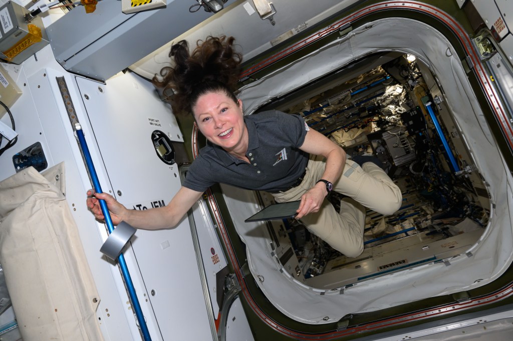 NASA astronaut and Expedition 71 Flight Engineer Tracy C. Dyson smiles for a portrait in the vestibule between the Kibo laboratory module and the Harmony module aboard the International Space Station.