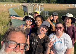 A group of people take a selfie in a marshland