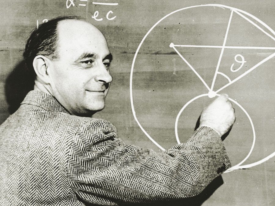 Italian-born physicist Dr. Enrico Fermi draws a diagram at a blackboard with mathematical equations. circa 1950.