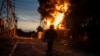 (FILE) A Ukrainian firefighter talks on the radio while he works to extinguish the fire on the site of an electrical substation that was hit by Russian strike in Dnipropetrovsk region, Ukraine, Monday, Sept. 2, 2024.