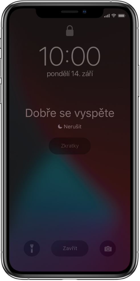 Displej iPhonu s nápisy „Dobře se vyspěte” a „Je zapnutí funkce Nerušit“ uprostřed. Pod nimi se zobrazuje tlačítko Zkratky. U dolního okraje jsou zleva doprava rozmístěná tlačítka Svítilna, Zavřít a Fotoaparát.