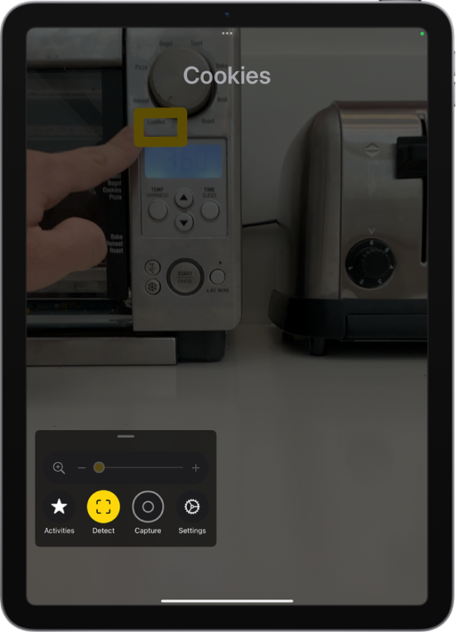 Apka Lupa deteguje prst, ktorý ukazuje na text na kuchynskom spotrebiči.