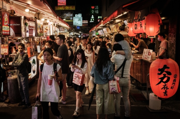 2024年5月26日，人们走过台北街道上的美食摊贩。（Yasuyoshi Chiba / AFP via Getty Images）