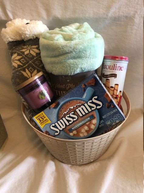 "Here is a fun gift basket for a \"Cozy Night In!\"  It contains the following: --1 pair of fuzzy socks --1 plush throw blanket --1 candle --1 package of cookies --1 box of hot cocoa packets  **Please note--Photo represents items that may be included.  All baskets will not contain the exact colors, brands, scents, and flavors of items as shown in this photo.** Basket will be wrapped in cellophane and tied with ribbon.  Will include hand written note, if requested." Cozy Night In Gift Basket, Night In Gift Basket, Basket Date, Hot Cocoa Packets, Photo Basket, Movie Basket Gift, Homemade Gift Baskets, Christmas Gift Baskets Diy, Raffle Basket